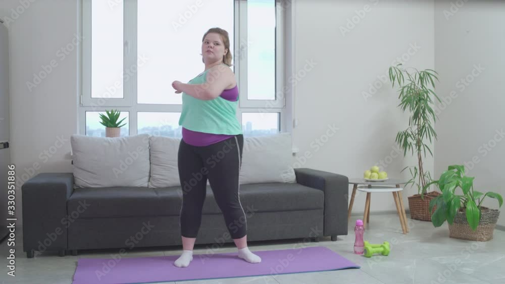 Active plus size female exercising home in morning, healthy lifestyle habit Active plus size female exercising home in morning, healthy lifestyle habit