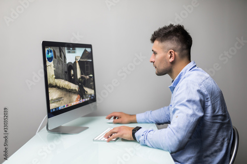 Fotografie, Obraz Professional gamer playing in first-person shooter online video game on his personal computer