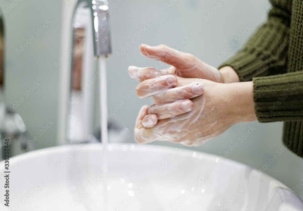 Woman washing hands in bathroom closeup Woman washing hands in bathroom closeup