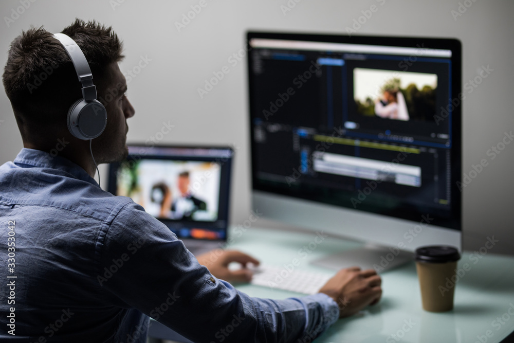 Young male editor editing video on computer at workplace office Young male editor editing video on computer at workplace office