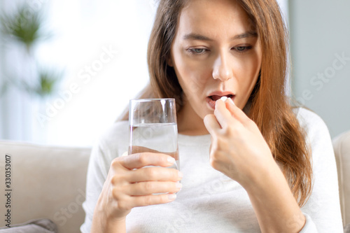 Young woman taking pill