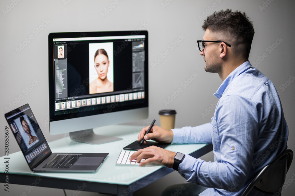Professional photographer works in photo editing app software on his personal computer. Photo editor retouching photos of beautiful girl. Professional photographer works in photo editing app software on his personal computer. Photo editor retouching photos of beautiful girl.