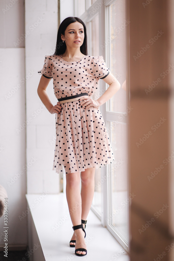 Beautiful brunette woman demonstrating spring clothes in studio