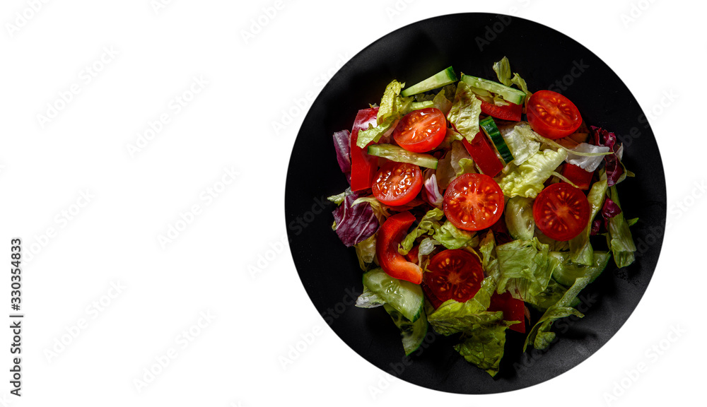 various fresh mix salad leaves with tomato, cucumber and red pepper on a black plate isolated on white background. with copy space. top view various fresh mix salad leaves with tomato, cucumber and red pepper on a black plate isolated on white background. with copy space. top view