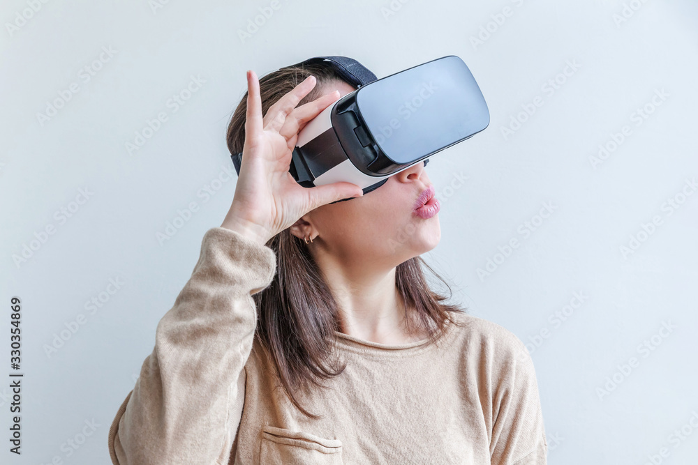 Smile young woman wearing using virtual reality VR glasses helmet headset on white background. Smartphone using with virtual reality goggles. Technology, simulation, hi-tech, videogame concept. Smile young woman wearing using virtual reality VR glasses helmet headset on white background. Smartphone using with virtual reality goggles. Technology, simulation, hi-tech, videogame concept.