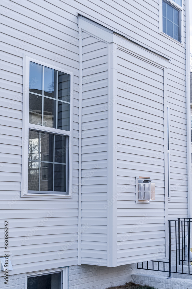 Typical bump-out on a new real estate property with white horizontal siding and a double sash window Typical bump-out on a new real estate property with white horizontal siding and a double sash window