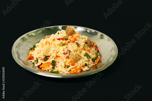 a plate of homemade fried rice recipe with vegetable slice isolated on black background