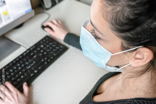 Business woman working from home wearing protective mask photo