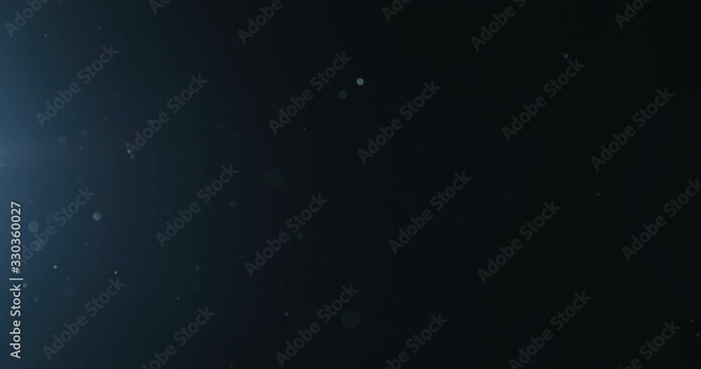 Slow motion natural dust particles float in air on black background Slow motion natural dust particles float in air on black background