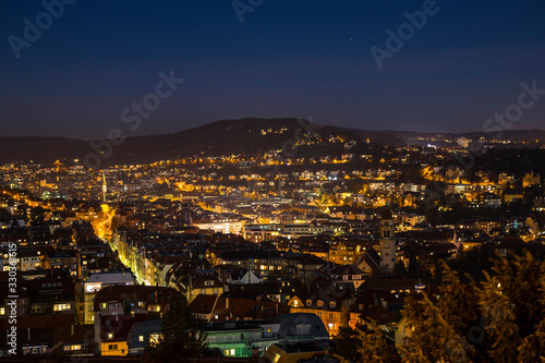 Obraz na płótnie Germany, Magical aerial view above illuminated skyline of city stuttgart houses in basin in clear winter night with starry sky and lots of lights w salonie