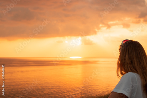 girl with long hair by the sea at sunset, summer vacation