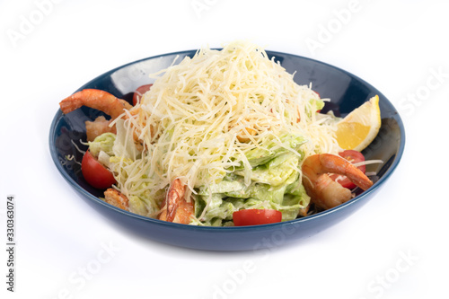 Caesar salad with shrimp on a white plate for menu and web