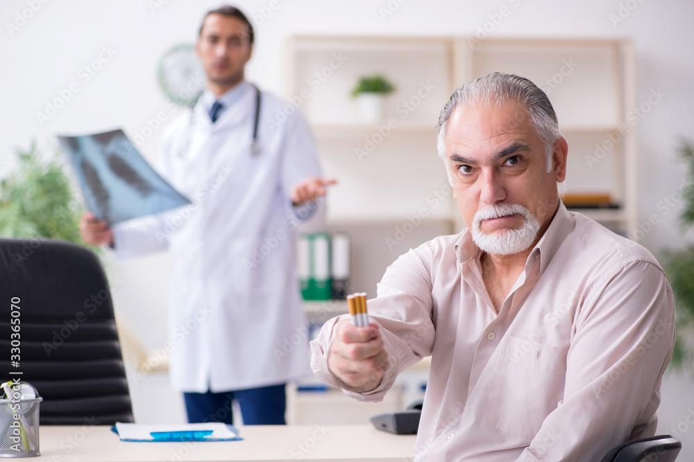 Young male doctor and old patient in antismoking concept Young male doctor and old patient in antismoking concept