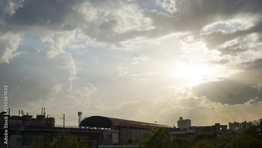 timelapse shot of metro station in jaipur with the white fluffy clouds moving in front of a sunset while the metro train comes and goes providing public transportation timelapse shot of metro station in jaipur with the white fluffy clouds moving in front of a sunset while the metro train comes and goes providing public transportation