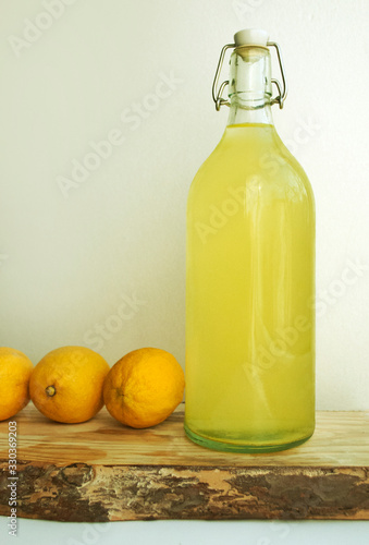 Homemade lemonade in an eco-friendly bottle, lemonade in reusable bottles. Lemons. Eco concept. Horizontal composition On a wooden kitchen board. Tree bark.