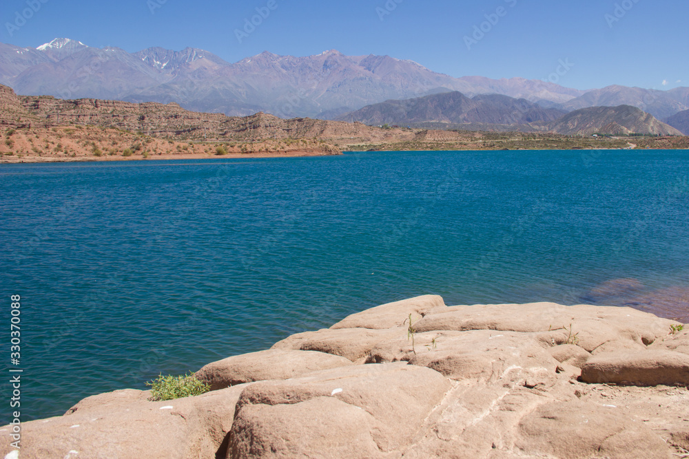 Embalse Lago con agua turquesa y tierra seca de Potrerillos en Mendoza Argentina
