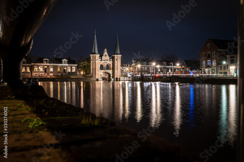 The famous historical 'Waterpoort' in the city of Sneek at night with reflections in the canal - Sneek, Friesland, The Netherlands