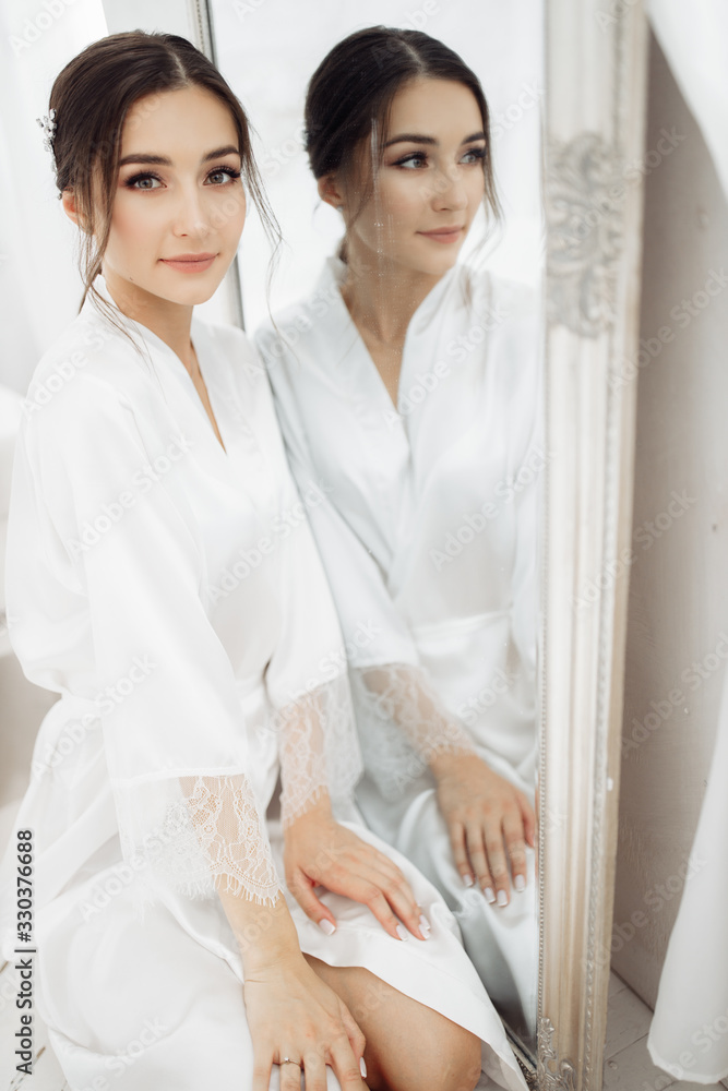 Elegant bride near the mirror at the morning Elegant bride near the mirror at the morning