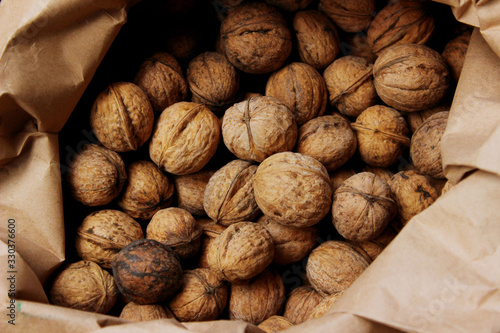 Cropped shot of walnuts. Abstract food background. Walnuts in a paper bag, close up.
