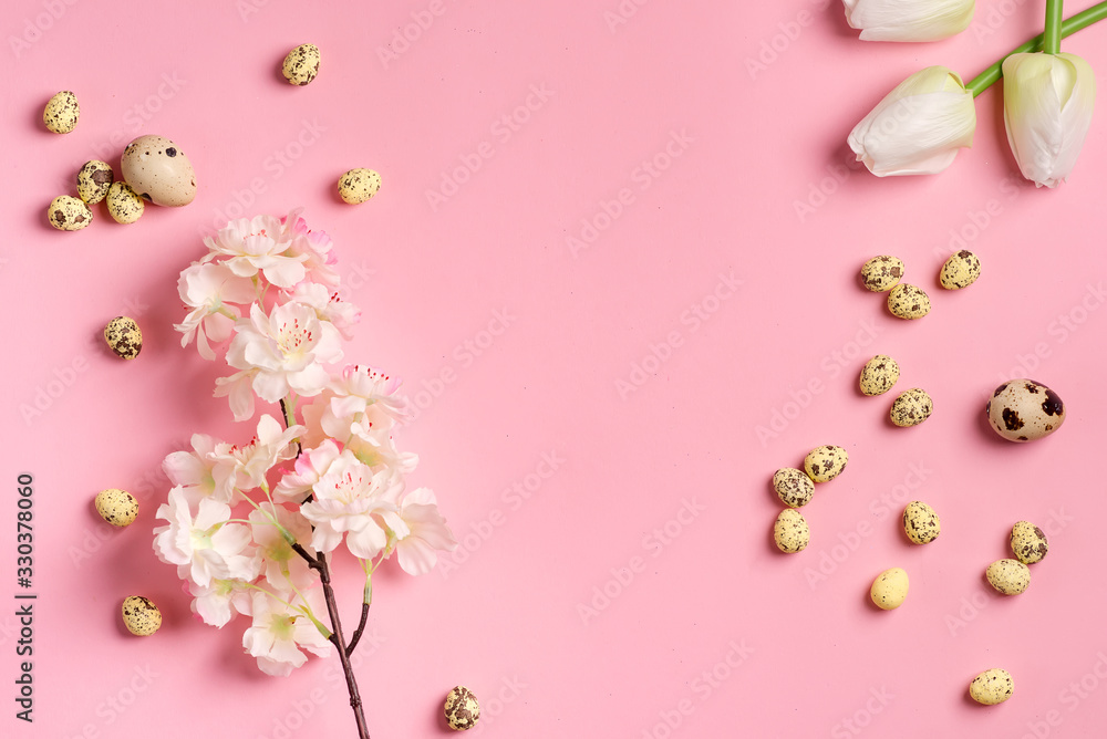 Easter festive composition from quail eggs, fresh tulips and cherries branch on a pink background.