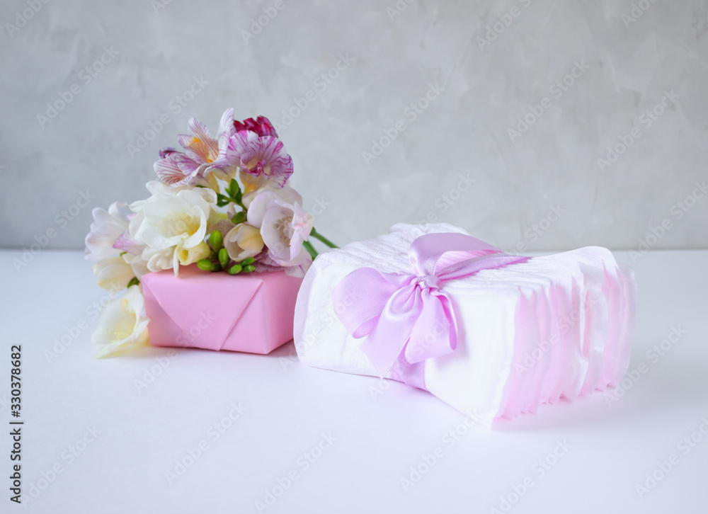 women's hygiene products in problem days and a box with spring flowers on a light background, the concept of women's health women's hygiene products in problem days and a box with spring flowers on a light background, the concept of women's health