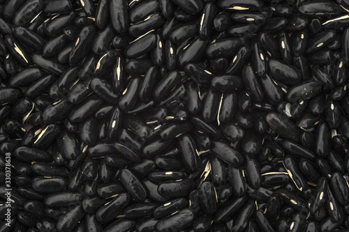 Top view of a heap of black beans. Raw black beans texture background. Close up.