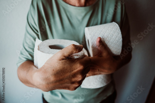 .Middle-aged woman hoarding a lot of toilet paper. Madness caused by the coronavirus health crisis. photo