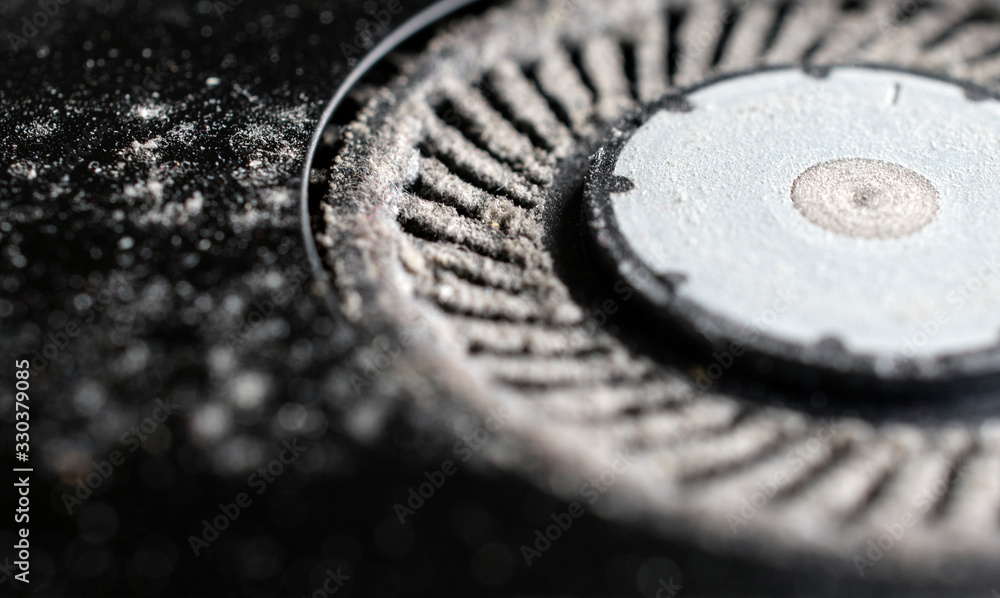 Dusty ventilating fan of an old overheated laptop in need of cleaning