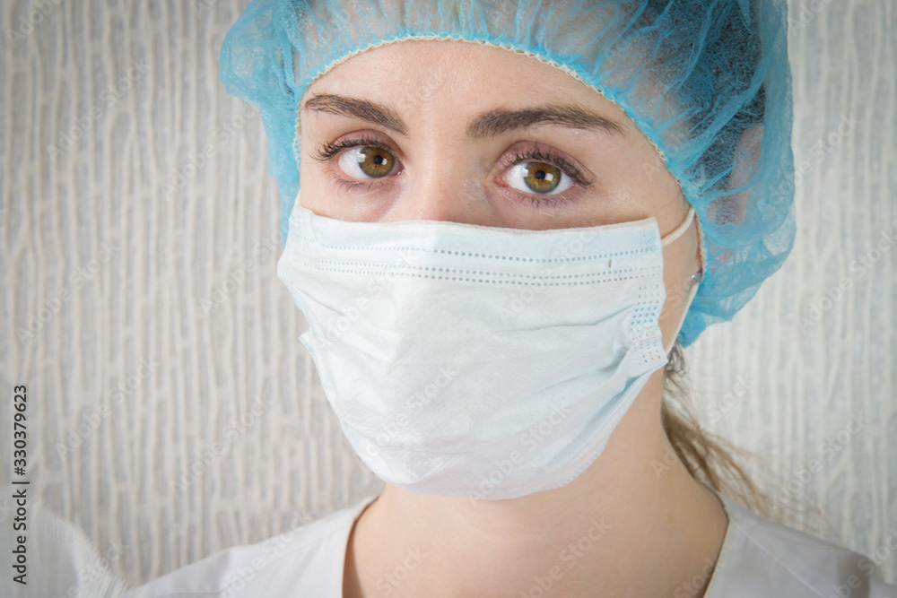 Nurse in a white mask. The face is close. Tired sad eyes of a paramedic after a hard day's work. coronavirus Nurse in a white mask. The face is close. Tired sad eyes of a paramedic after a hard day's work. coronavirus