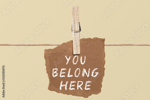 You belong here    A paper on the pegs. And this is the word written.