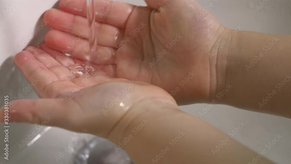 Child washing hands to prevent the spread of disease of coronavirus, virus or bacterial infection. Closeup hands, sink, running water Child washing hands to prevent the spread of disease of coronavirus, virus or bacterial infection. Closeup hands, sink, running water