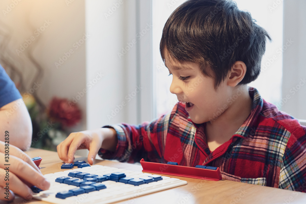Preschool kid playing English words game,Child boy concentrated with spelling English letter with parent at home. Activity for children for play and learn, Education and Homeschooling concept Preschool kid playing English words game,Child boy concentrated with spelling English letter with parent at home. Activity for children for play and learn, Education and Homeschooling concept