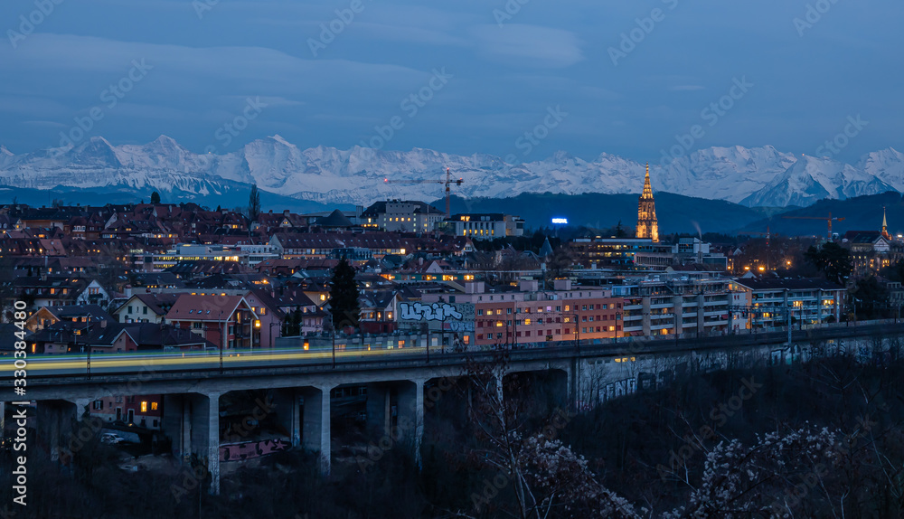 BERN, SWITZERLAND - MARCH 8, 2020: Night panoramic view of the Swiss capital of Bern with the Alps in the background