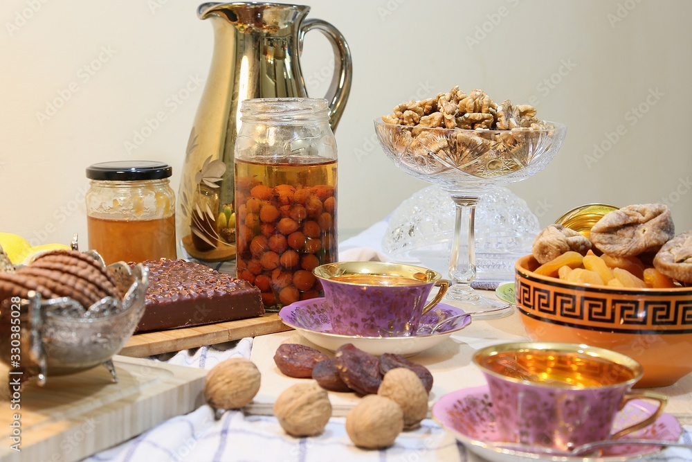 On the table there are sweets: cake, dry fruits, nuts and jam view