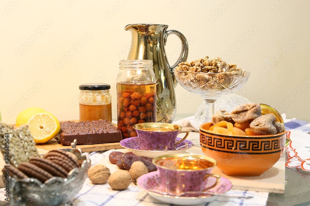 On the table there are sweets: cake, dry fruits, nuts and jam view On the table there are sweets: cake, dry fruits, nuts and jam view