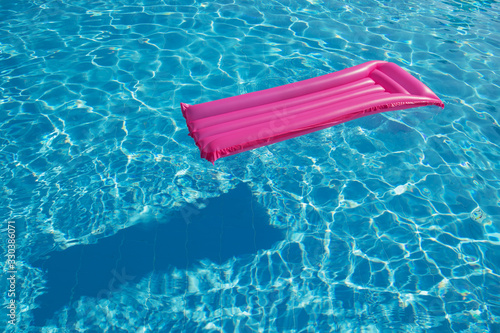 Pink inflatable mattress floating on water surface