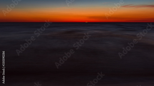 calm sea at sunset, a moment before the sun disappears behind the horizon