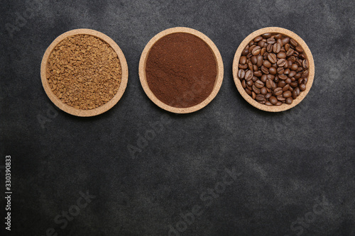 Coffee various - roasted beans or grain and ground and instant coffee on black fabric background. The sequence of preparation of the drink. Coffee concept. Flat lay. Top view. Copy space for text.
