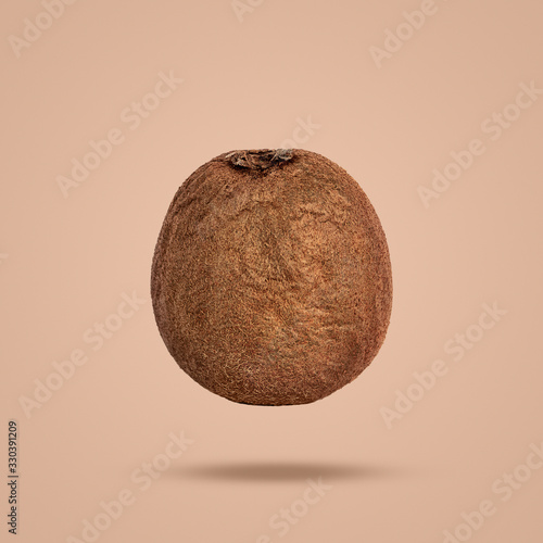 flying ripe kiwi isolated on brown background