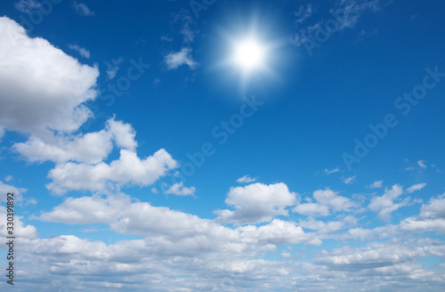 Blue sky with clouds and sun.