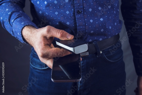 man holds phone and external battery