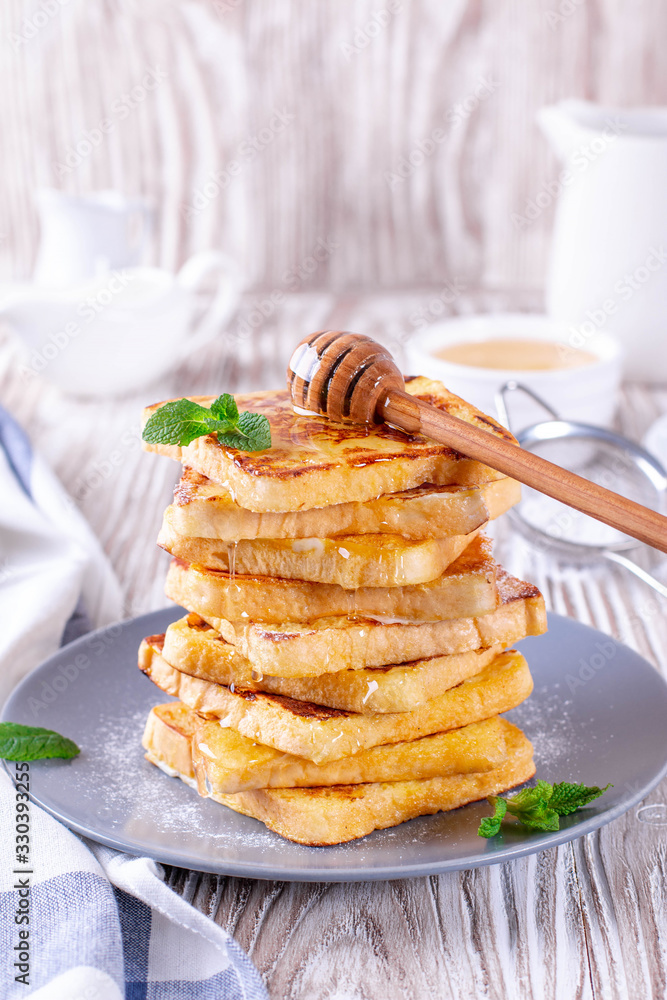 Fresh homemade crispy toast with honey on white wooden table