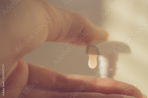 Fotografija Female finger touch on a liquid soap dispenser