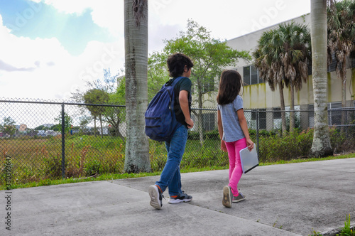 coronavirus kids school walking bro sis young boy girl holding book walk in hold notebook empty young boy girl waiting ride home pickup covid19