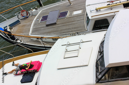 Little boy spoiling on the deck of a yacht in Paris, summer vacation.