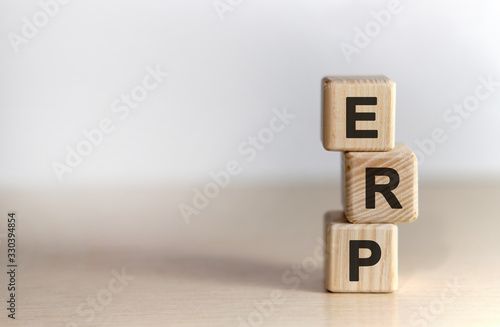 ERP - Enterprise Resource Planning on wooden cubes, on wooden background