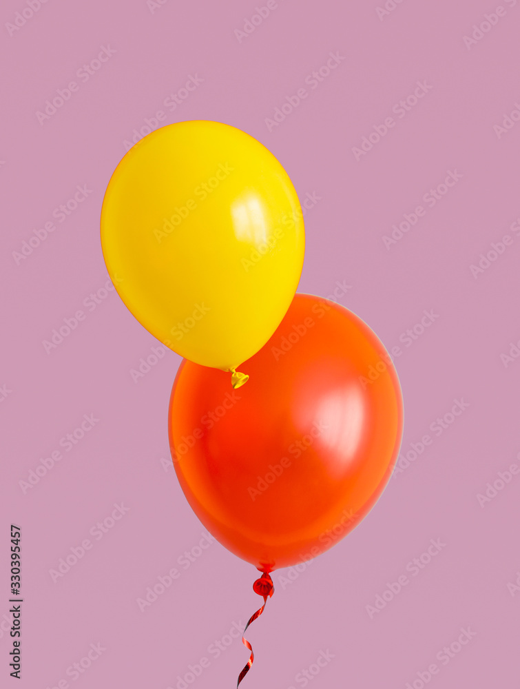 Yellow and red balloons are flying over the purple background. Yellow and red balloons are flying over the purple background.