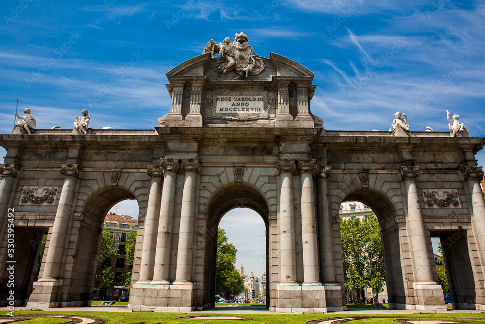 Obraz premium The famous Puerta de Alcala on a beautiful sunny day in Madrid City. Inscription on the pediment: Rey Carlos III year 1778
