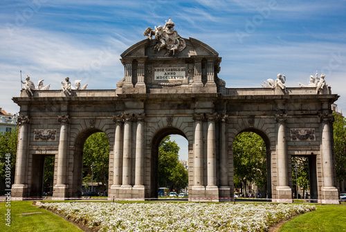 The famous Puerta de Alcala on a beautiful sunny day in Madrid City. Inscription on the pediment: Rey Carlos III year 1778
