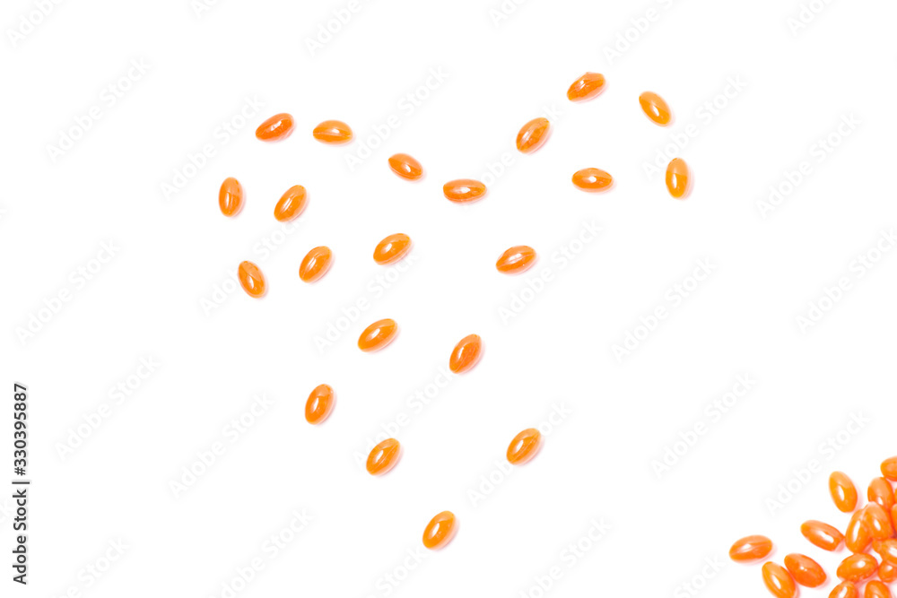 The orange tablets are laid out in the shape of a heart on a white background The orange tablets are laid out in the shape of a heart on a white background